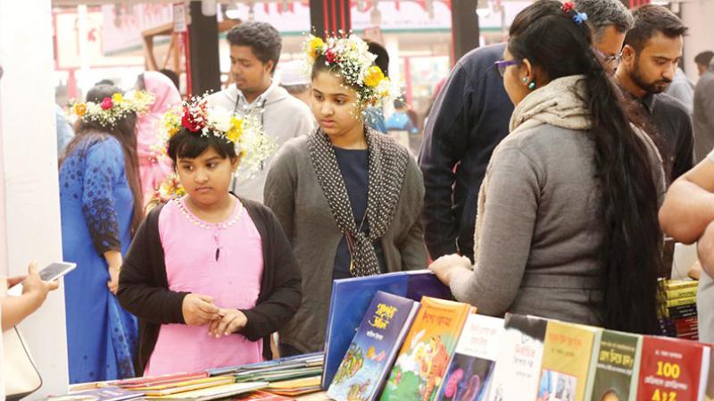 Two youngsters are seen checking out books at a stall during ‘Children’s Hour’ in Eukshey Book Fair on Friday (Feb 02) (Photo: Dhaka Tribune)