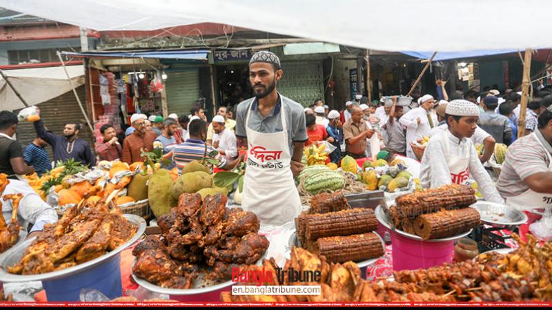 Different types of kebabs, lamb leg roast and fruits are being sold.
