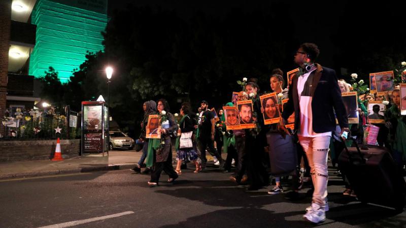 Relatives, survivors and friends of victims of the Grenfell tower fire walk to the tower to hold a vigil, one year after the fire in London, Britain June 13, 2018. REUTERS