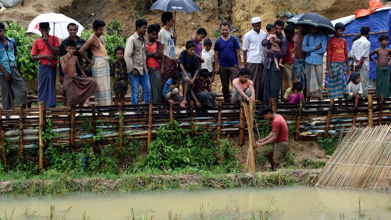 People stand on a pathway after a storm at the Chakmarkul Rohingya refugee camp in Cox`s Bazar, Bangladesh June 10, 2018. Picture taken June 10, 2018. REUTERS