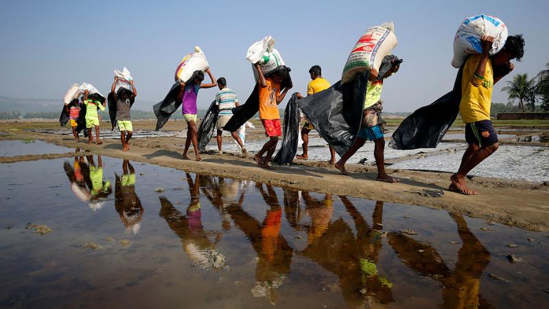 Rohingya refugee workers carrying bags of salt this month in a processing yard in Cox`s Bazar REUTERS FILE PHOTO
