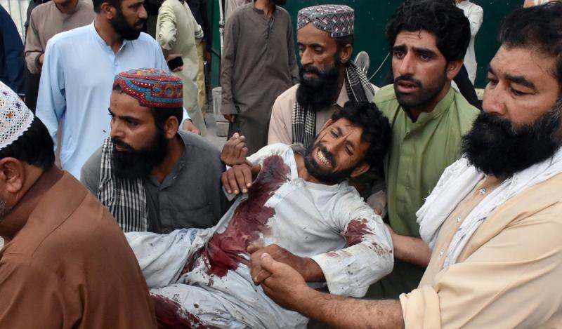Men move an injured after a suicide attack during an election campaign meeting, outside a hospital in Quetta, Pakistan July 13, 2018. REUTERS