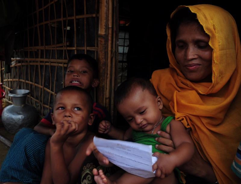 Sait Banu sits at her bamboo shelter with her children at a Rohingya refugee camp in Cox`s Bazar, Bangladesh, holding a letter she received from her husband imprisoned in Myanmar, June 28, 2018. Picture taken June 28, 2018. REUTERS