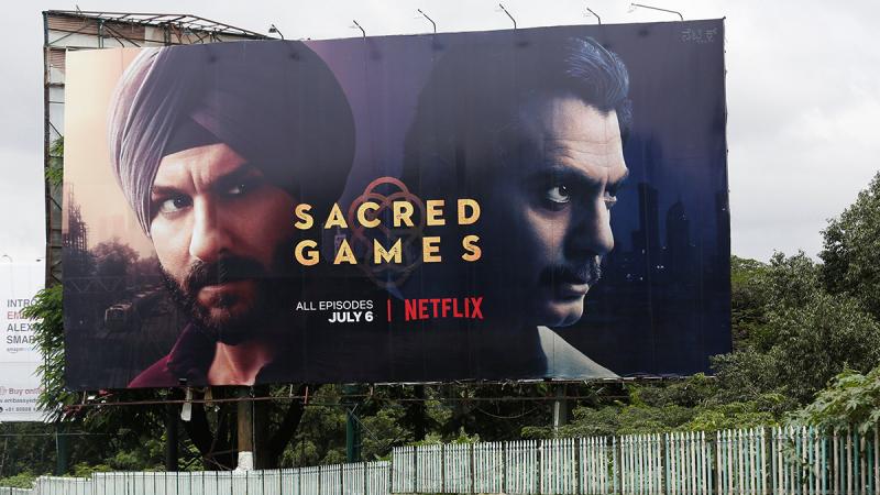 A man rides his scooter past a hoardings of Netflix`s new television series `Sacred Games` in Bengaluru, India, July 11, 2018. Picture taken July 11, 2018. REUTERS