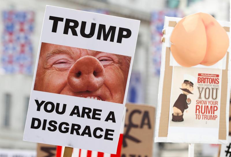 Demonstrators protesting against the visit of U.S. President Donald Trump, hold up placards in central London, Britain, Jul 13, 2018. REUTERS