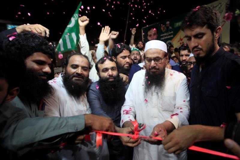 Hafiz Muhammad Saeed, chief of the Islamic charity organisation Jamaat-ud-Dawa (JuD), cuts a ribbon to inaugurates an election office of the newly formed political party Allah-o-Akbar Tehreek, in Lahore Pakistan July 14, 2018. Picture taken July 14, 2018. REUTERS