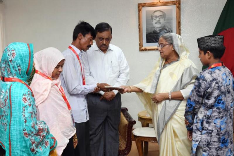 PM Sheikh Hasina hands over Tk 2 million saving certificates each to the victim families.