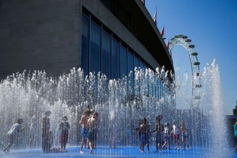 People play amongst the fountains outside the Royal Festival Hall in London, Britain, August 3, 2018. REUTERS