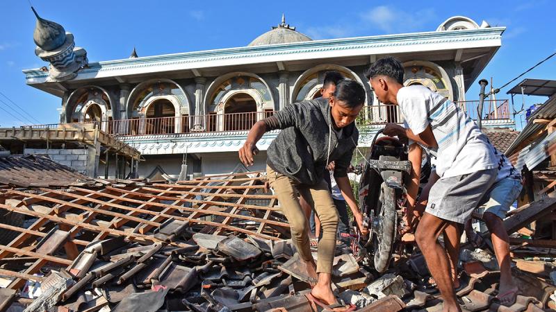People recover a motorcycle from a damaged home near a mosque after a strong earthquake in Gunungsari, West Lombok, Indonesia, Aug 6, 2018. REUTERS