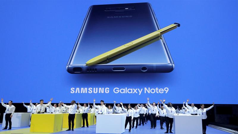Samsung employees wave from stage beneath an image of the new Samsung Galaxy Note 9 during a product launch event in Brooklyn, New York, US, Aug 9, 2018. REUTERS