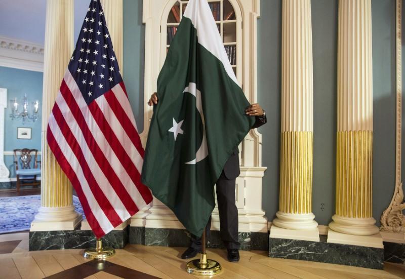 A State Department contractor adjust a Pakistan national flag before a meeting between U.S. Secretary of State John Kerry and Pakistan`s Interior Minister Chaudhry Nisar Ali Khan on the sidelines of the White House Summit on Countering Violent Extremism at the State Department in Washington February 19, 2015. REUTERS