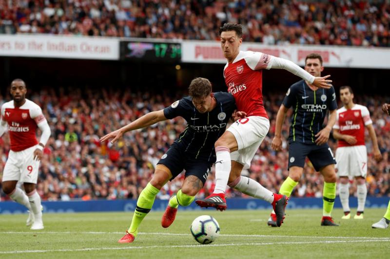 Arsenal`s Mesut Ozil in action with Manchester City’s John Stones at Emirates Stadium, London, Britain on August 12, 2018. REUTERS