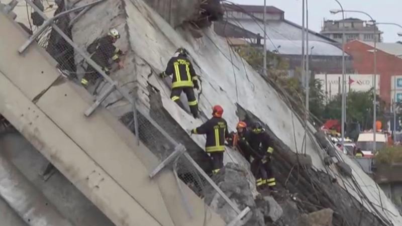 Rescue workers are seen at the collapsed Morandi Bridge in the Italian port city of Genoa, Italy August 14, 2018 in this still image taken from a video. Local Team via Reuters TV/REUTERS
