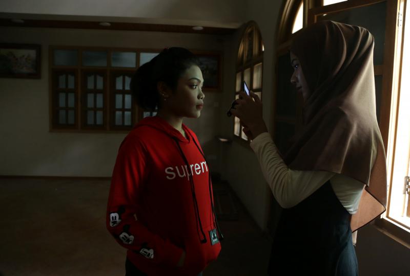 Blogger Win Lae Phyu Sin, 19, takes a photograph of a student after teaching them how to apply makeup in Yangon, Myanmar, January 27, 2018. REUTERS
