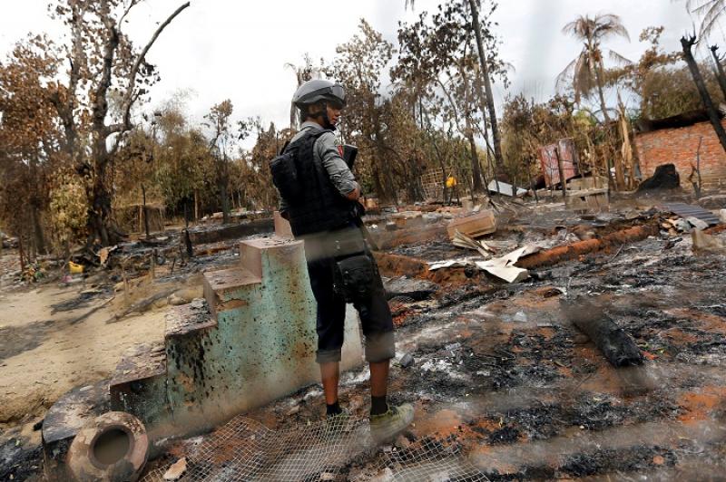 A police officer stands in a house that was burnt down during the days of violence in Maungdaw, Myanmar, August 30, 2017. REUTERS/FILE PHOTO