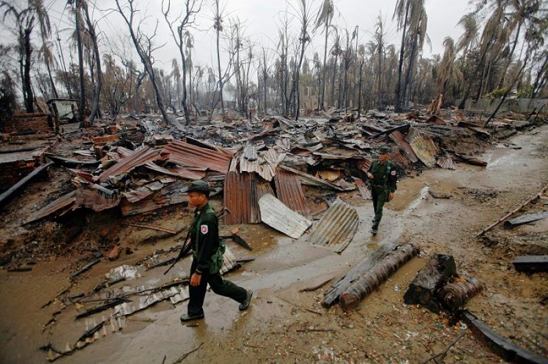 Soldiers patrol through a neighbourhood that was burnt during recent violence in Sittwe June 14, 2012. REUTERS/FILE PHOTO