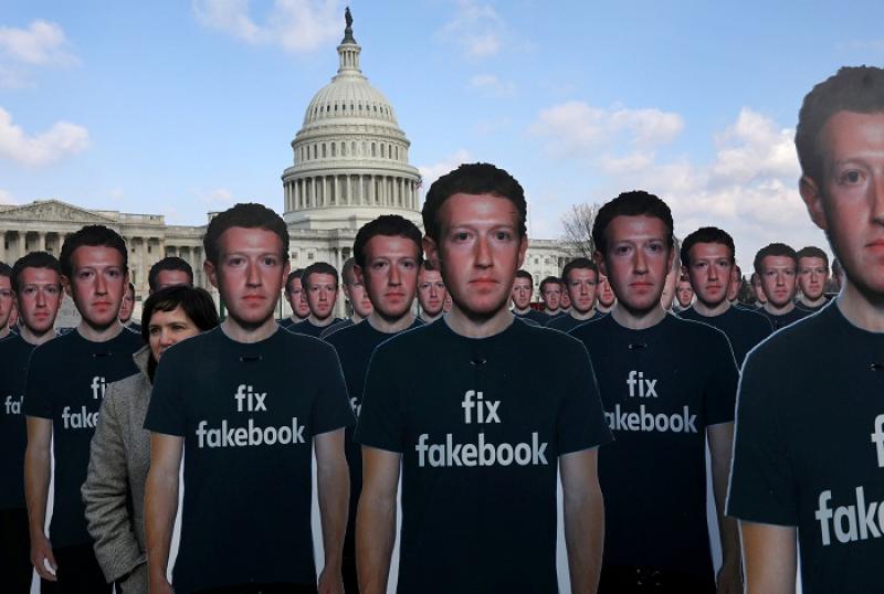 Avaaz.org Campaign Director Nell Greenberg, (L), walks among dozens of cardboard cut-outs of Facebook CEO Mark Zuckerberg while holding a protest outside of the U.S. Capitol building in Washington, U.S., April 10, 2018. REUTERS/FILE PHOTO