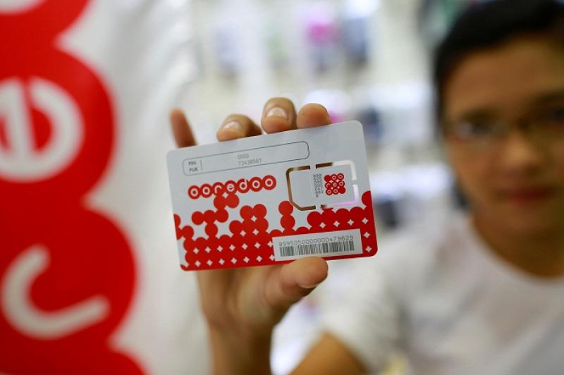 A woman shows a SIM card from Qatar`s Ooredoo after buying it from a phone shop in Yangon July 31, 2014. REUTERS/FILE PHOTO