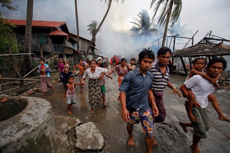 Rohingyas run away from a fire that was set to a part of Sittwe, during clashes June 10, 2012. REUTERS/FILE PHOTO