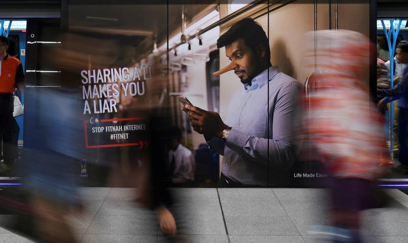 An advertisement discouraging the dissemination of fake news is seen at a train station in Kuala Lumpur, Malaysia March 28, 2018. REUTERS