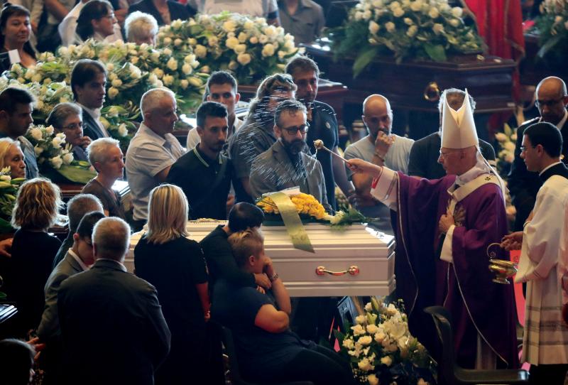 Archbishop of Genoa, Cardinal Angelo Bagnasco, blesses the coffin during the state funeral of the victims of the Morandi Bridge collapse, at the Genoa Trade Fair and Exhibition Centre in Genoa, Italy August 18, 2018. REUTERS