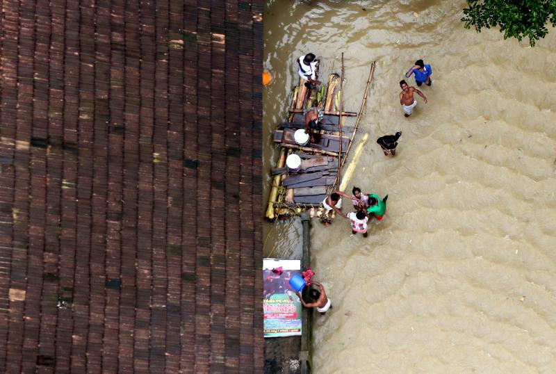 People wait for aid next to makeshift raft at a flooded area in the southern state of Kerala, India, August 19, 2018. REUTERS
