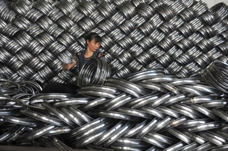 A woman works on packaging bicycle rim steels for export at a workshop of a company manufacturing sports equipments in Hangzhou, Zhejiang province, China, June 4, 2018. Reuters/File Photo