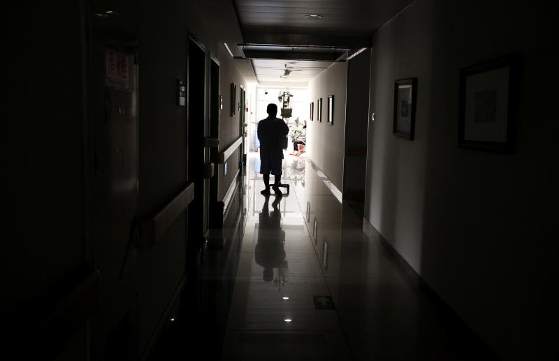 A cancer patient pushes his drip stand as he walks down the hallway of a hospital in Beijing, China July 12, 2011. REUTERS/FILE PHOTO