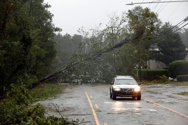 A motorist drives away from a fallen tree blocking a road after the arrival of Hurricane Florence in Wilmington, North Carolina, U.S., September 14, 2018. REUTERS