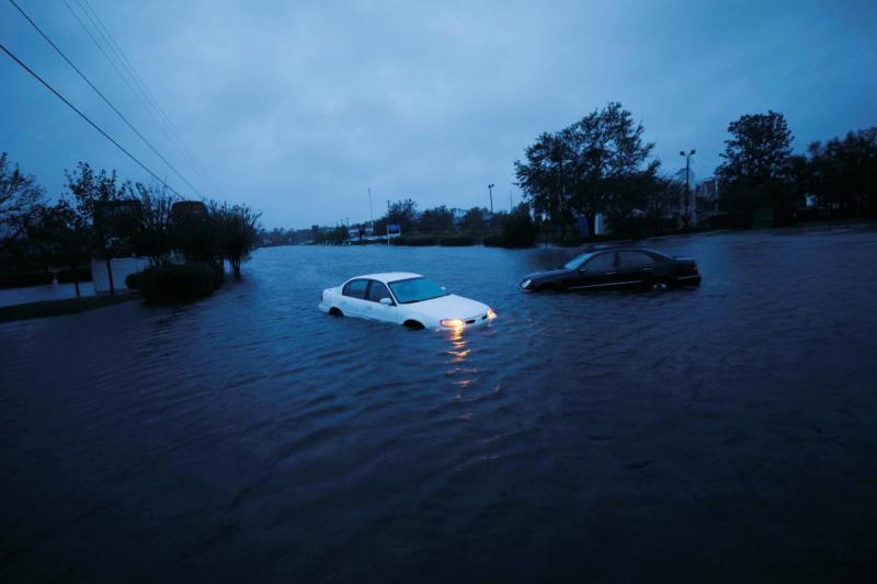 An abandoned car`s hazard lights continue to flash as it sits submerged in a rising flood waters during pre-dawn hours after Hurricane Florence struck in Wilmington, North Carolina, September 15, 2018. REUTERS