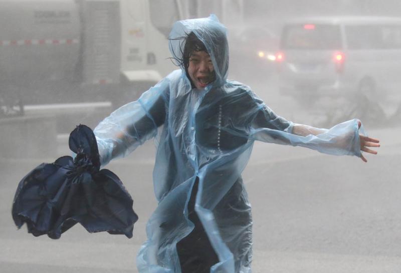 A woman runs in the rainstorm as Typhoon Mangkhut approaches, in Shenzhen, China September 16, 2018. REUTERS