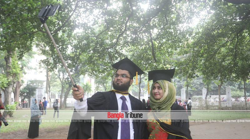 Two graduates wearing gown take a selfie on the campus on Friday (Oct 5). PHOTO:Sazzad Hossain