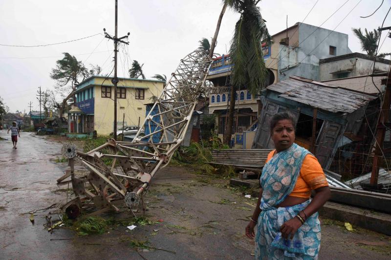 A woman stands next to a damaged communication tower after cyclone Titli hit in Srikakulam district in the southern state of Andhra Pradesh, India, October 11, 2018. REUTERS