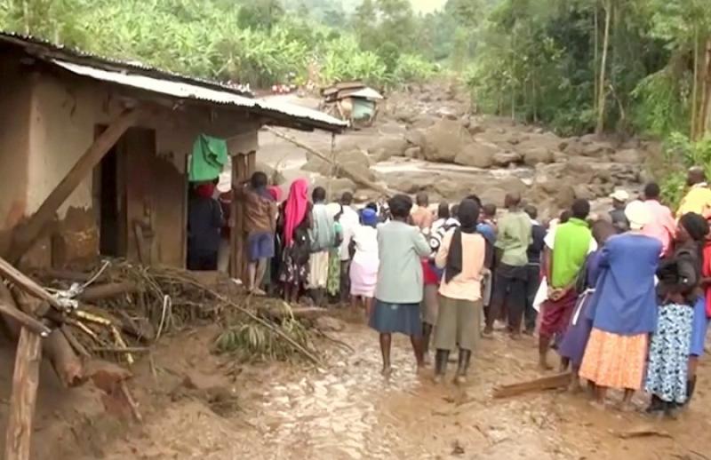 Residents watch flood waters pass through destroyed homes, after a landslide in Bududa, Uganda, in this still image taken from video on October 12, 2018. Reuters TV/via REUTERS