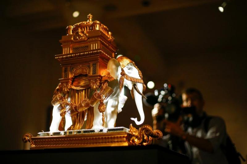 A man films `The Baccarat Elephant Cave A Liqueur` during a photocall for `The Midas Touch` collection Sotheby`s in London, Britain, October 12, 2018. REUTERS