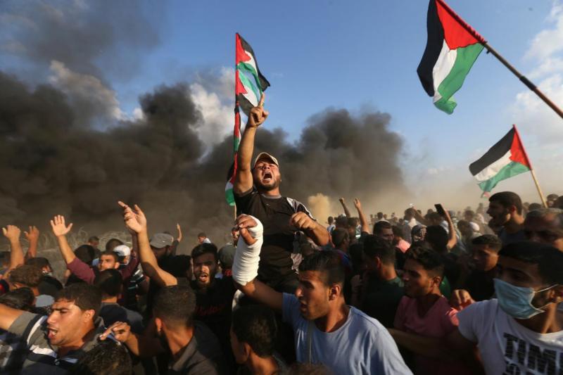 Palestinians shout slogans during a protest calling for lifting the Israeli blockade on Gaza and demanding the right to return to their homeland, at the Israel-Gaza border fence in the southern Gaza Strip October 12, 2018. REUTERS