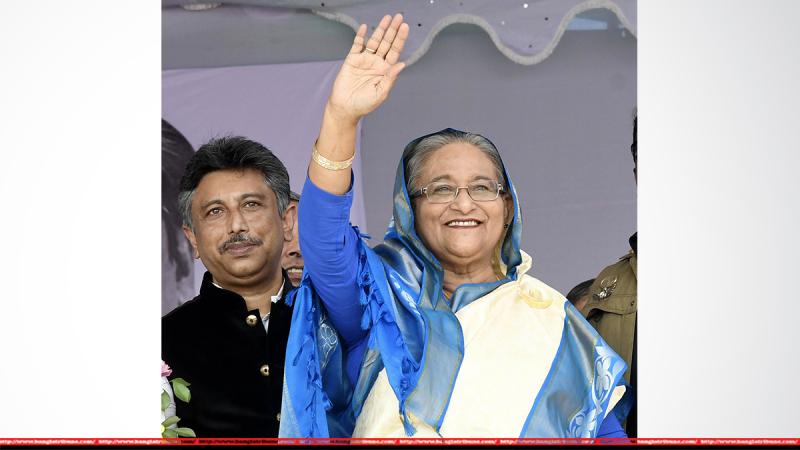 Prime Minister Sheikh Hasina waves hand at a public rally organbized by Madaripur’s Shibchar Upazila unit of Awami League in Kathalbari Ferryghat area on Sunday (Oct 14).