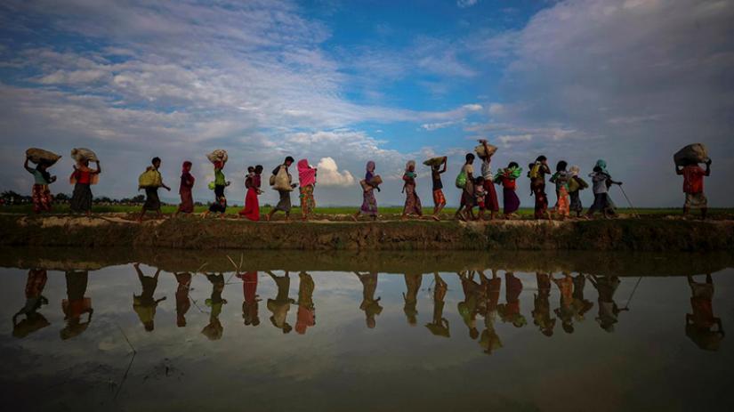 Rohingya refugees are reflected in rain water along an embankment next to paddy fields after fleeing from Myanmar into Palang Khali, near Cox`s Bazar, Bangladesh November 2, 2017. (Photo: Reuters)