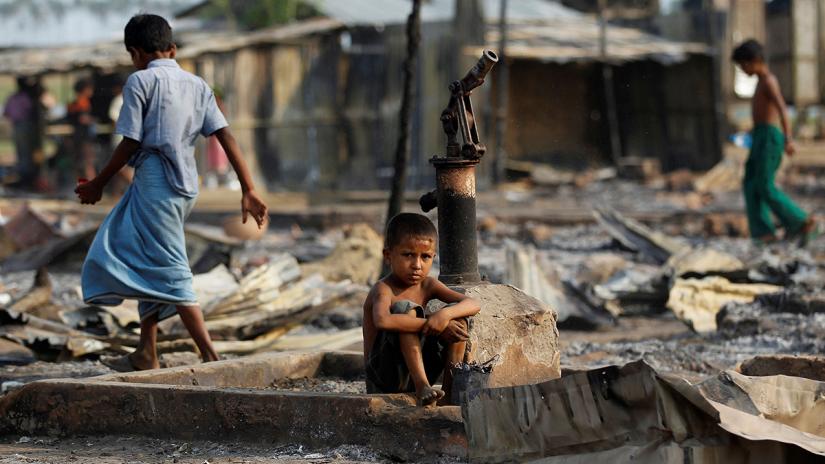 A boy sits amid the wreckage of shelters destroyed by a fire at a camp for displaced Rohingya near Sittwe, the Rakhine capital, in May 2016. REUTERS/Soe Zeya Tun