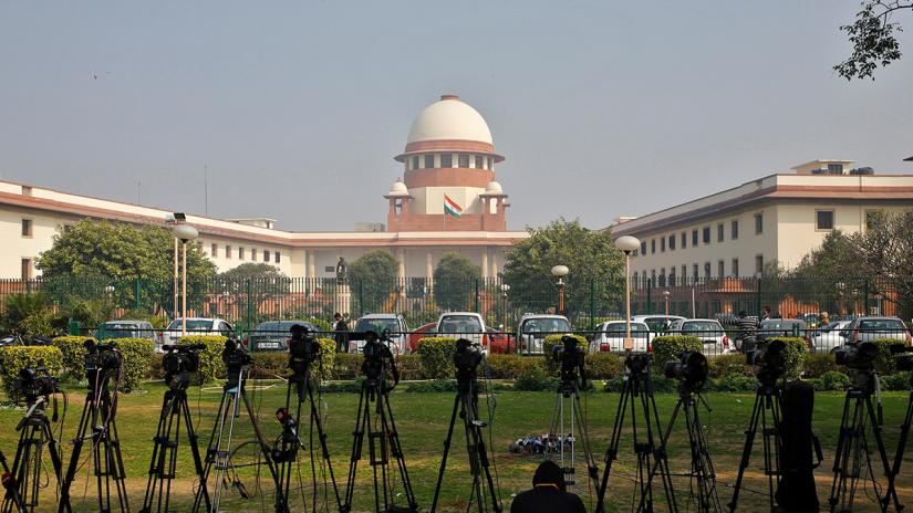 Television journalists set the camera inside the premises of the Supreme Court in New Delhi February 18, 2014. REUTERS FILE PHOTO