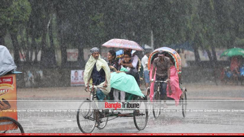 Three passengers on a Rickshaw during the downpour Monday afternoon. PHOTO: Nashirul Islam
