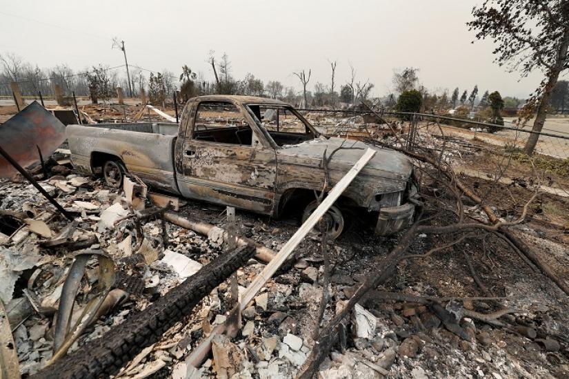 The scorched shell of a truck sits next to a house that burned in the Carr Fire, west of Redding, California, U.S. July 27, 2018. REUTERS