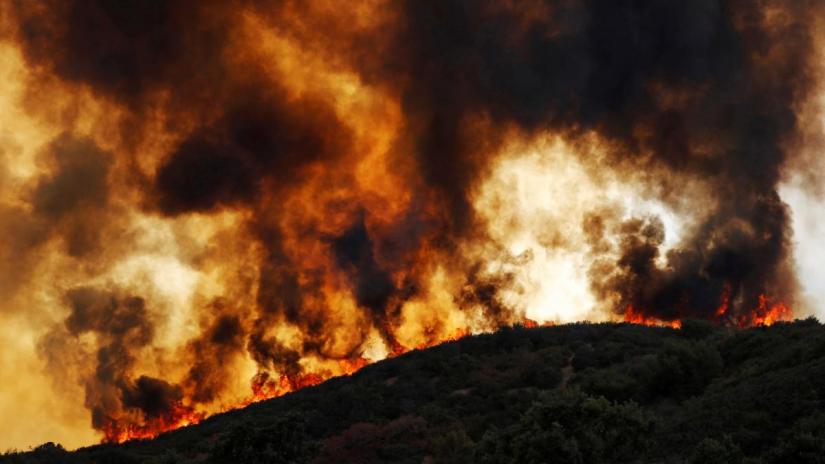 Wind-driven flames roll over a hill towards homes during the River Fire (Mendocino Complex) near Lakeport, California, U.S. August 2, 2018. REUTERS