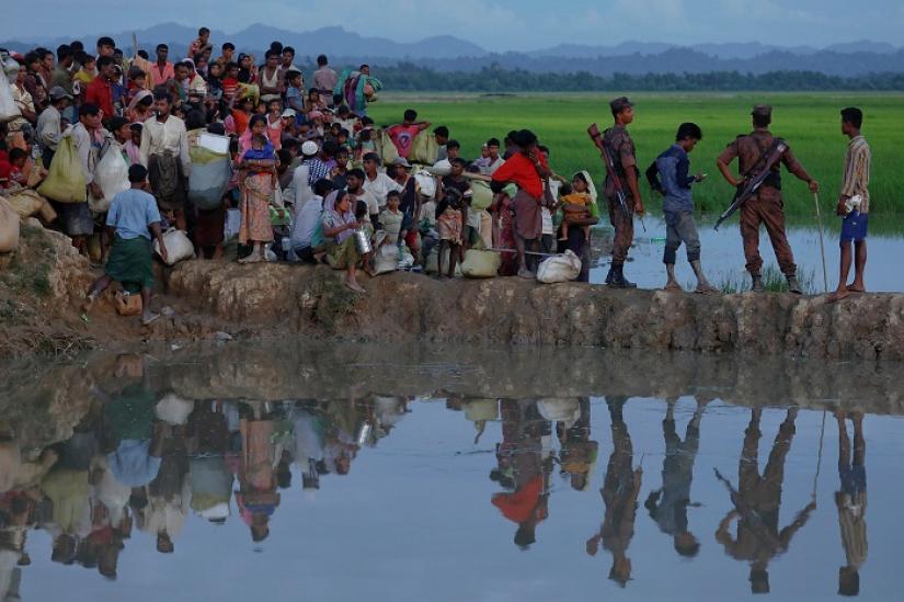 Rohingya refugees who fled from Myanmar wait in the rice field to be let through after after crossing the border in Palang Khali, Bangladesh October 9, 2017. REUTERS/FILE PHOTO