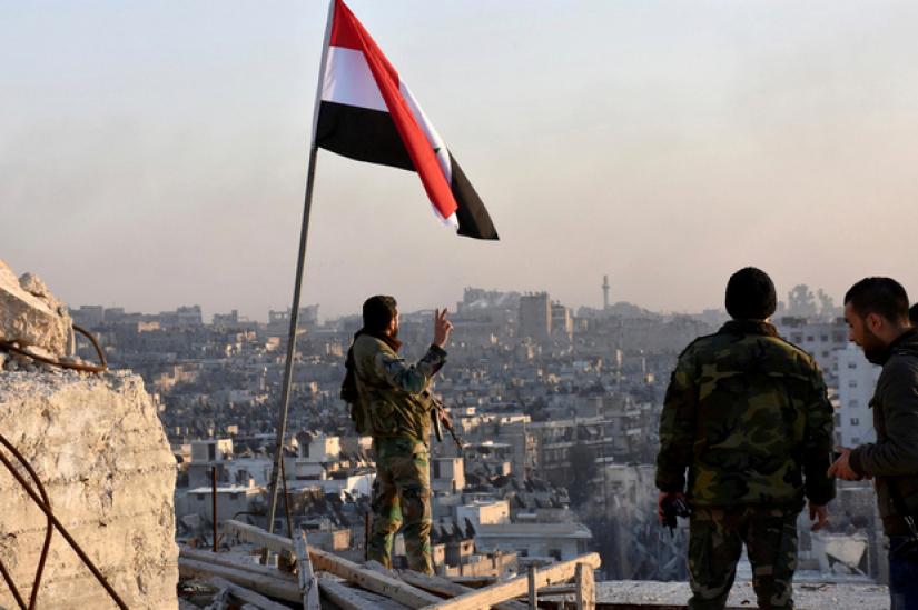 Syrian forces raise their flag over an area of Aleppo. REUTERS/FILE PHOTO