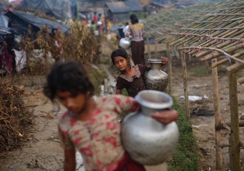 Rohingya refugee girls carry metal pitchers with water at Balukhali makeshift refugee camp in Cox`s Bazar, Bangladesh, September 13, 2017. REUTERS FILE PHOTO