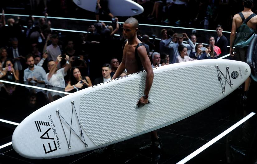 Models carry surfboards as they present creations at Emporio Armani REUTERS