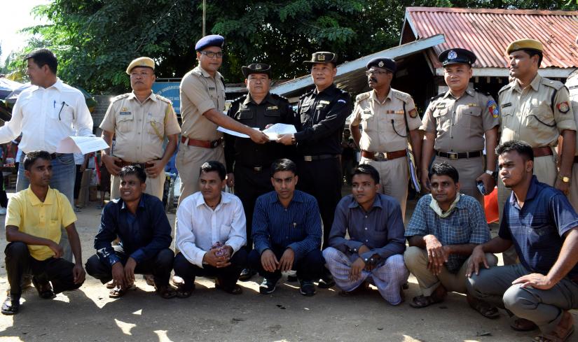 The seven Rohingya men to be deported sit as Indian and Myanmar security officials exchange documents before their deportation on India-Myanmar border at Moreh in the northeastern state of Manipur, India, October 4, 2018.  REUTERS