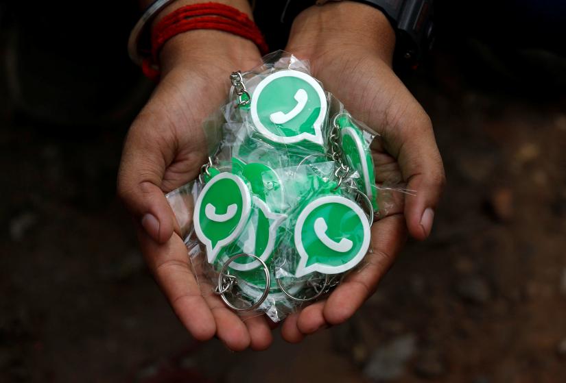 A WhatsApp-Reliance Jio representative displays key chains with WhatsApp logo for distribution during a drive to educate users, on the outskirts of Kolkata, India, Oct 9. REUTERS
