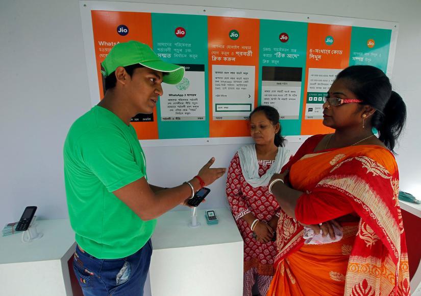A WhatsApp-Reliance Jio representative explains how to use Facebook Inc`s WhatsApp messenger to a woman during a drive by the two companies to educate users, on the outskirts of Kolkata, India, October 9, 2018.REUTERS